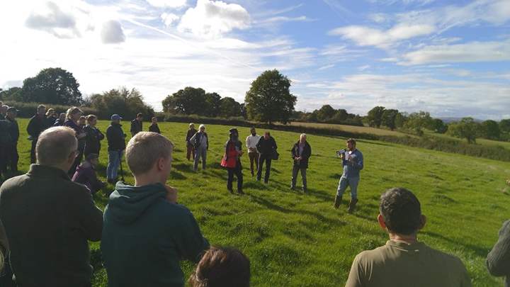 Farmer Billy Lewis talking in a field to a group of people