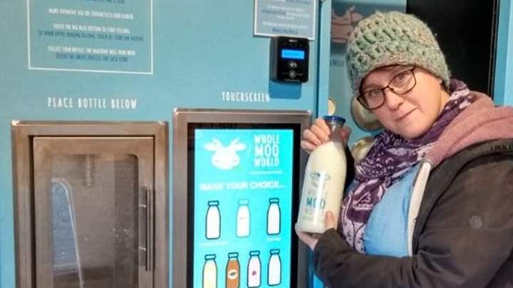 Lady purchasing milk from a vending shed in Herefordshire