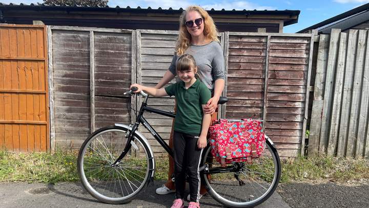 Photo of lady and child with a bike that they have won in a prize draw by making a Greener Footprints pledge